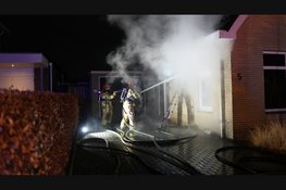 Fikse brand in spouwmuur van woning. Brandweer slaat stenen uit muur om te blussen